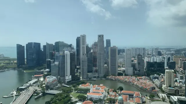 Aerial view of Singapore’s city centre with office towers, low-rise shophouse streets and the harbour beyond