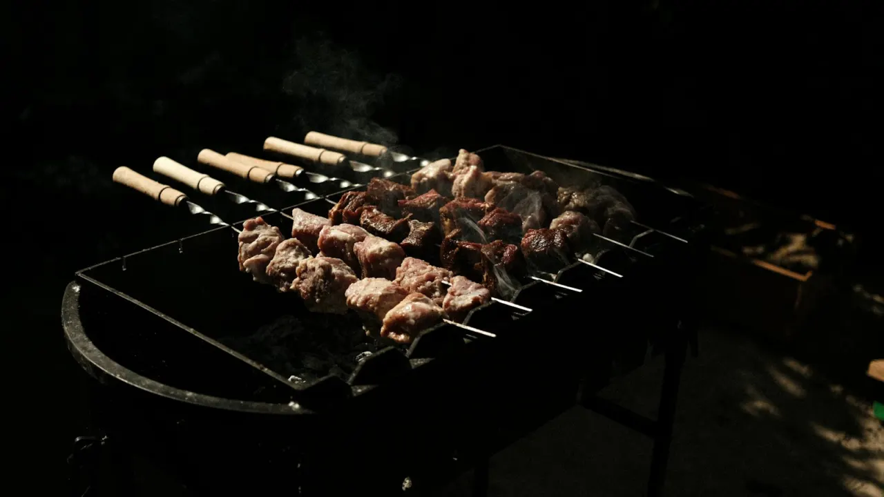 Skewers of meat grilling over glowing charcoal