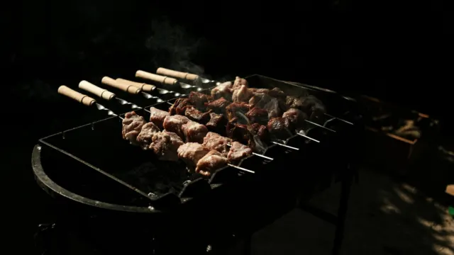 Skewers of meat grilling over glowing charcoal