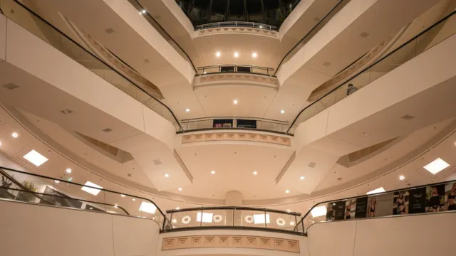 Multi-level shopping mall atrium with balconies of shopfronts rising around an open centre