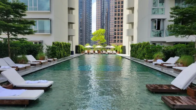 Long lap pool with sun loungers between residential blocks