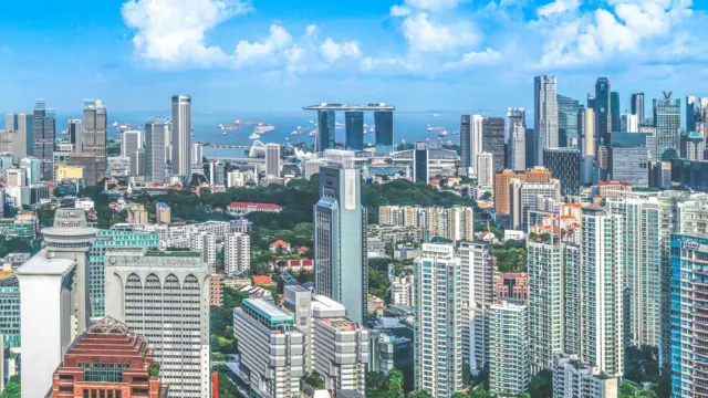 Aerial view of dense high-rise residential blocks and green trees in Singapore