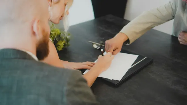 Couple signing a document together at a desk