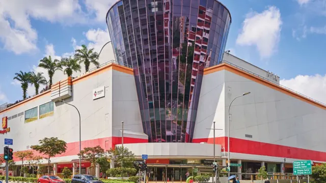 Hougang Mall’s glass-fronted entrance tower on Hougang Avenue 10 under a blue sky