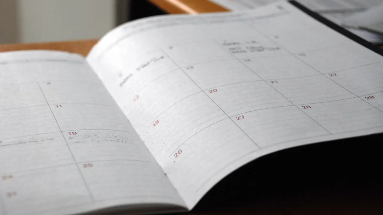 Open monthly planner on a wooden desk for scheduling a showflat visit