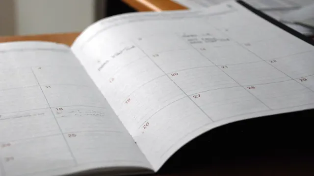 Open monthly planner on a wooden desk for scheduling a showflat visit