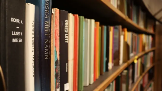 Close-up of a curved bookshelf packed with colourful book spines