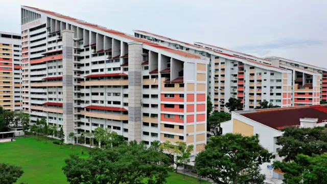 Aerial view of a multi-storey apartment block with a green lawn in Singapore