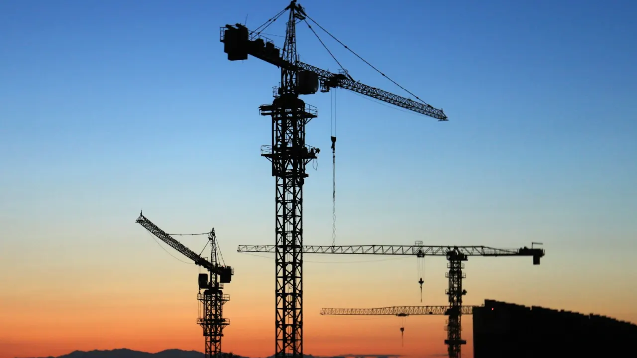 Tower cranes above a building site at golden hour