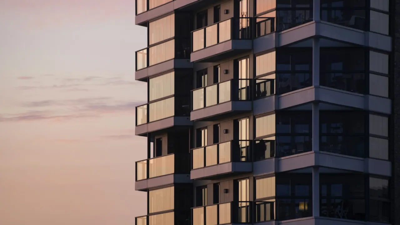 Modern apartment building with glass balconies at dusk