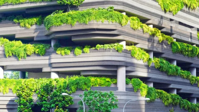 Concrete building with tiers of greenery and trees planted along each level