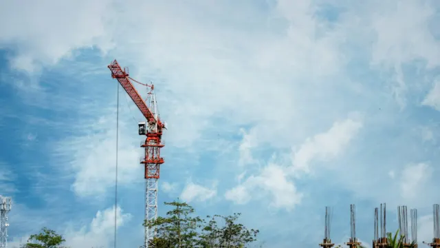 Construction crane against a cloudy blue sky