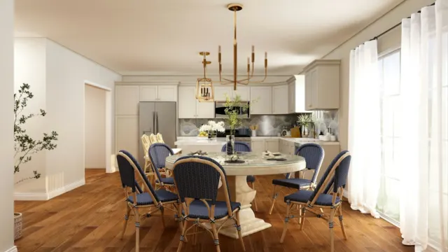 Bright open-plan dining area with a round table, chairs and a kitchen beyond