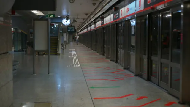 Underground MRT platform with platform screen doors and a commuter walking along it