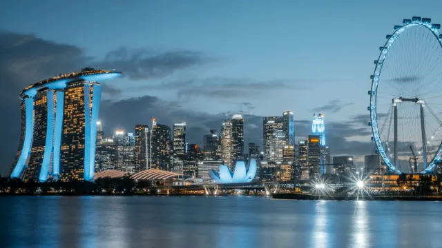 新加坡滨海湾一带的城市天际线夜景，高楼灯光倒映在水面上